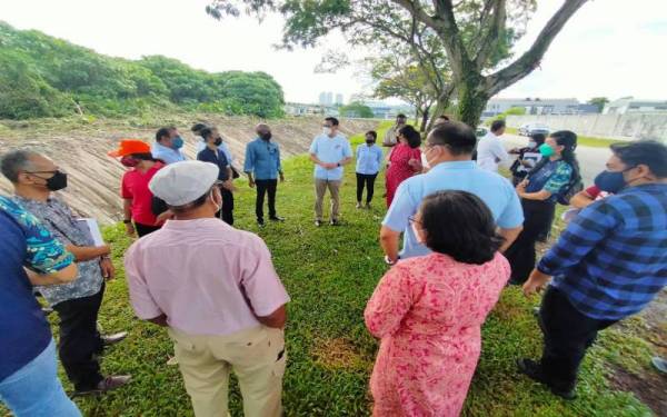 Chen (tengah) ketika menemui penduduk yang membantah pembatalan pembinaan klinik berhampiran tapak projek itu pada Khamis