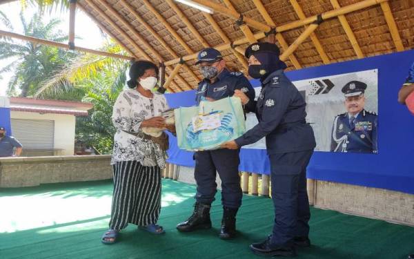 Abdul Latif menyerahkan sumbangan barangan keperluan kepada keluarga Orang Asli di Kampung Orang Asli Bukit Tadom, Kuala Langat pada Jumaat.