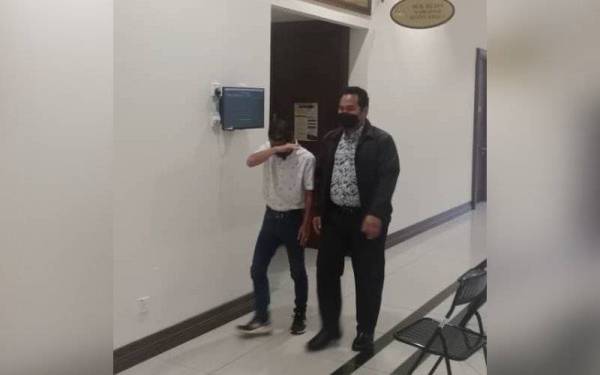 Tertuduh (kiri) ketika hadir di Mahkamah Sesyen Khas Rasuah Kota Kinabalu.