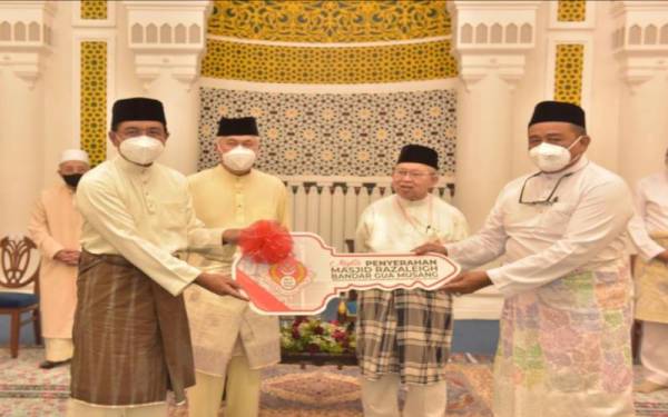 Simbolik penyerahan replika kunci Masjid Razaleigh daripada Ab Aziz kanan) kepada Zulkifle (dua dari kiri) di saksikan Tengku Tan Sri Mohamad Rizam Tengku Abdul Aziz (tiga dari kiri) dan Tengku Razaleigh (dua dari kanan). - Foto MAIK