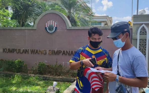 Dua pencarum, Mohamad Faiz Abdul Kalid (kiri) dan Mohd Faiz Mohd Shafie memeriksa maklumat peribadi di Pejabat KWSP Kuala Terengganu.