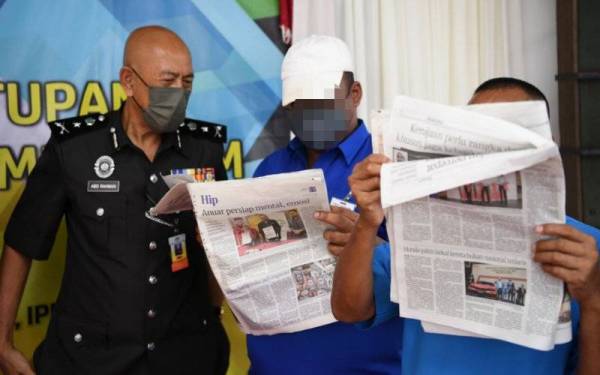 Abd Rahman (kiri) melihat kebolehan dua banduan membaca akhbar ketika Perasmian Penutupan Program Literasi Membaca 3M Banduan Penjara Seremban pada Jumaat. - Foto Bernama