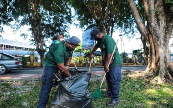 Dua kakitangan MDPT sedang membersihkan kawasan persekitaran tapak bazar Ramadan di pekan Kuala Nerang di sini pada Sabtu.