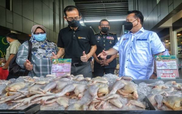 Alexander Nanta (kanan) meninjau harga barangan keperluan asas selepas melancarkan Ops Pantau dan Talian Aduan sempena Bulan Ramadan dan Hari Raya Aidilfitiri di sebuah pasar raya di Kuching, pada Ahad. - Foto Bernama