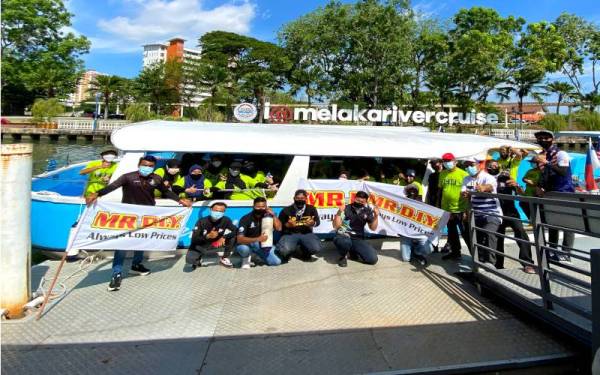 Azlam (lima dari kanan berdiri) bersama sukarelawan yang bersama-sama membersihkan Sungai Melaka.