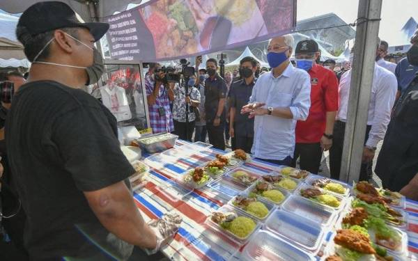 Ismail Sabri beramah mesra dengan para peniaga semasa melakukan tinjauan di Bazar Ramadan Putrajaya 2022 Presint 3 pada Isnin. - Foto Bernama
