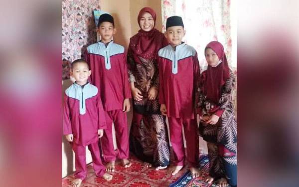 Muhammad Nasruddin (dua dari kanan) bergambar bersama keluarganya pada tahun lalu. - Foto Noor Fazlin