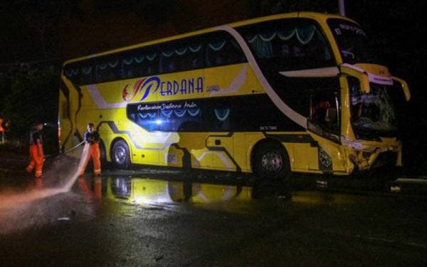 Anggota Jabatan Bomba dan Penyelamat Malaysia membersihkan kawasan kemalangan yang membabitkan empat mangsa yang maut dalam kejadian di Kampung Sungai Ikan Jalan Kuala Terengganu-Kota Bharu. - Foto Bernama