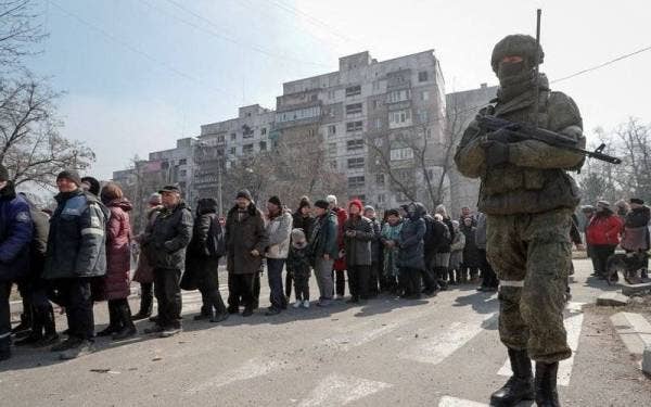 Gambar fail menunjukkan seorang askar Rusia mengawal orang awam untuk mendapatkan bantuan kemanusiaan di Mariupol, Ukraine. - Foto Reuters
