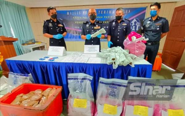 Zaizul Rizal (dua dari kiri) bersama pegawainya menunjukkan daun ketum serta barang rampasan dalam serbuan di dua lokasi berasingan di Selising, Pasir Puteh.