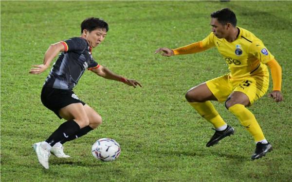 Pemain Sarawak United, Lee Changhoon (kiri) cuba mengelecek pemain Penang FC pada saingan Liga Super di Stadium Negeri, pada Selasa.