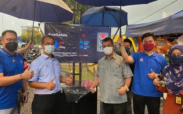 Mohamad Azhan (dua kiri) meninjau paparan sistem CCS yang dipasang di SS 6/1 Kelana Jaya pada Selasa bagi mengawal jumlah pengunjung di bazar berkenaan.