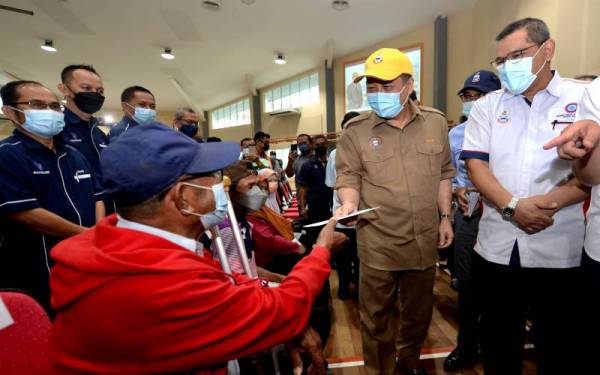 Hajiji (dua dari kanan) menyampaikan sumbangan Bantuan Wang Ihsan kepada salah seorang ketua isi rumah yang terbabit dalam kebakaran di Kampung Kurnia Jaya, Batu 4, Jalan Apas di Dewan Masyarakat Tawau pada Rabu. - Foto Bernama