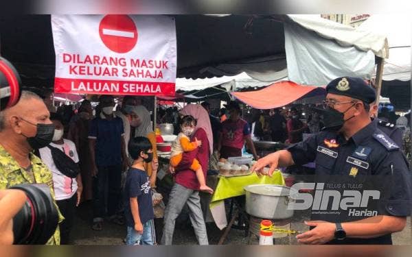 Shafien (kanan) melihat penanda laluan yang dibuat oleh urusetia FAMA Kelantan.