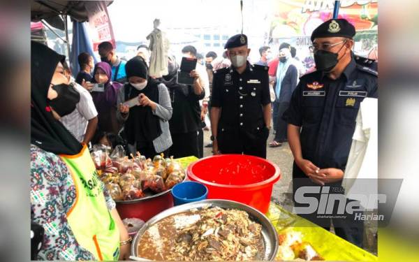 Shafien (kanan) melawat gerai menjual perut, limpa dan kerabu kaki ayam di bazar Ramadan di Stadium Sultan Muhammad IV, Kota Bharu.