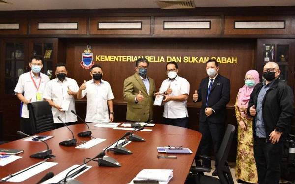 Ellron (empat dari kiri) menerima cenderahati daripada Sabarudin dalam kunjungan hormat di pejabatnya di Wisma Muis, Kota Kinabalu.
