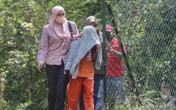 Kelihatan suspek dibawa keluar dari lokasi.