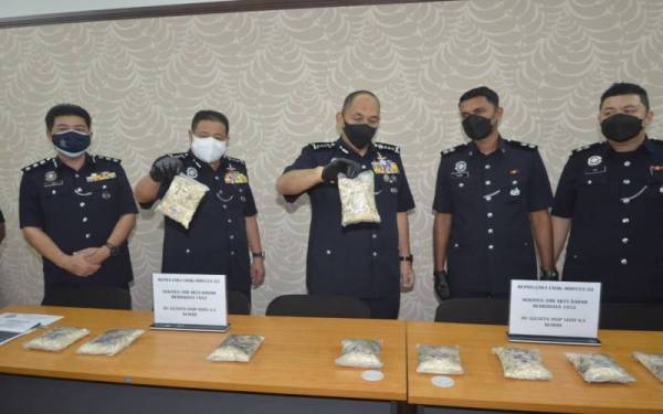 Mior Faridalathrash (tengah) menunjukkan bungkusan heroin yang ditemui pada seorang lelaki yang ditahan di Teluk Intan.