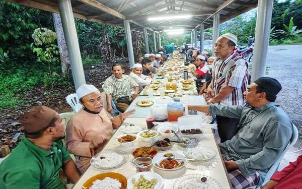 Mustapa (dua dari kiri) berbuka puasa bersama penduduk Kampung Kubang Rusa pada Khamis.