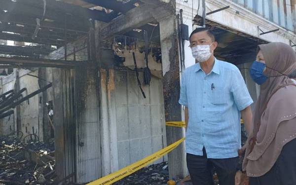 Salasiah (kanan) dan Siew Kiong melihat keadaan kedai di Jalan Alsagoff yang terbakar Rabu lalu.