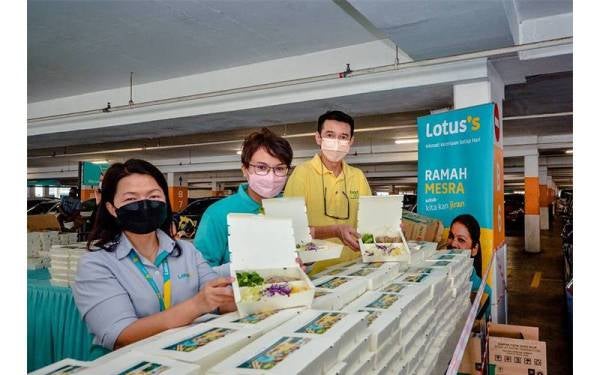 Siuew Luan (kiri), Ketua Komunikasi dan CSR Lotus’s Malaysia, Hanim Hamdan (tengah) dan Kean Soon menunjukkan bungkusan makanan yang telah siap untuk diagihkan kepada penerima.