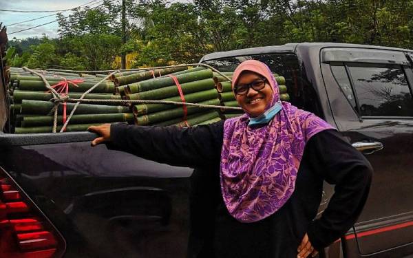 Lailawati bersama buluh lemang yang sedia untuk dihantar kepada pelanggan.