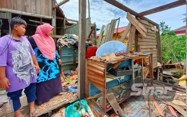 Wan Akid Afham dan ibunya melihat keadaan terkini rumah mereka yang sedang dirobohkan untuk proses bina baharu.