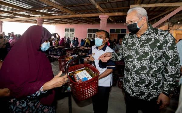 Annuar (kanan) menyampaikan bakul Ramadan kepada masyarakat setempat di Kadok, Kota Bharu pada Sabtu. - Foto: Bernama