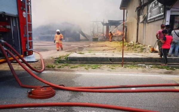 Anggota bomba memadam kebakaran melibatkan enam buah rumah terletak di Jalan Keretapi Dalam Rhu, Tumpat, pada Sabtu. Foto Ihsan Bomba