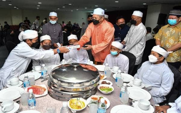 Annuar (tengah) menyampaikan sumbangan kepada pelajar Ma'ahad Tahfiz Wal Tarbiyyah Darul Iman pada Majlis Iftar Menteri Komunikasi dan Multimedia Bersama Komuniti Negeri Terengganu di Kuala Terengganu malam ini.