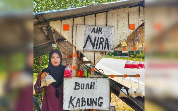 Mariati bersama buah kabung yang dijual di gerai miliknya