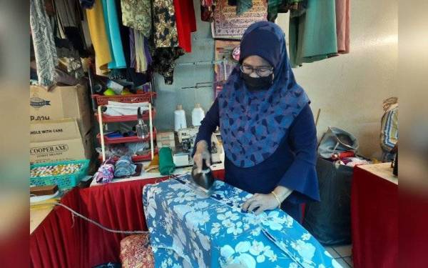 Zaiton menggosok fabrik sebelum menjahit.