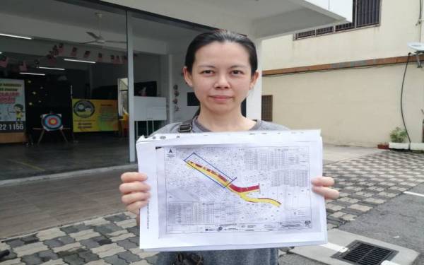 Mai Ling menunjukkan pelan cadangan pengambilan tanah bagi projek naik taraf Jalan Persekutuan FT3210.