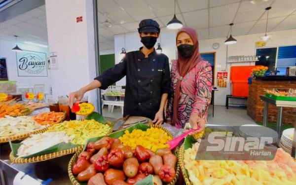 Pemilik Bayam Street Kitchen di Jalan Bayam, Maziah (kanan) masih lagi mengekalkan harga colek seperti tahun lalu walaupun berlaku kenaikan harga bahan mentah.