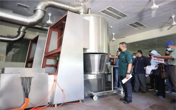 Dr Azman (kiri) meninjau kilang tepung ubi vitato Kampung Pengkalan Kubor, Tembila, Besut yang dibina pada 2012 tapi masih belum beroperasi.