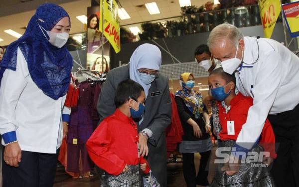 Siti Zailah bersama Dr Ameer (kanan) mengayakan pakaian raya kepada Ziyad Zaim Mohd Shukor dan Irfan Iyaz Mohd Shukor selepas selesai majlis Mydin Prihatin Syawal yang diadakan di Pasar Raya Mydin di sini pada Isnin. - Foto Sinar Harian ROSLI TALIB