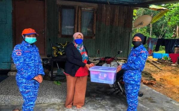 Anggota APM menyerahkan kit makanan kepada mangsa banjir di Lipis, pada Isnin. - Foto ihsan APM