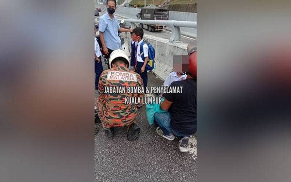 Anggota bomba menyelamatkan kanak-kanak yang menaiki van sekolah yang terlibat dalam kemalangan di Jalan Pantai Dalam, Kuala Lumpur pada Isnin.