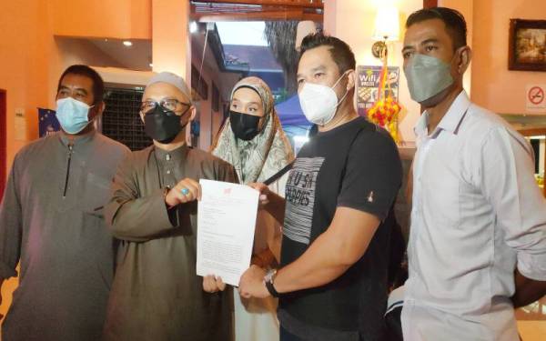 Mohd Aluwi (dua, kiri) menunjukkan surat yang diterima mengenai pembubaran jawatankuasa parti peringkat negeri di Ayer Keroh, pada Isnin.