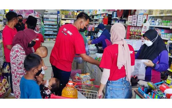 Kakitangan redONE membantu Nurfauziana dan anak-anak membeli kelengkapan Ramadan di sebuah pasar raya di Pekan Kuala Ketil, Baling.