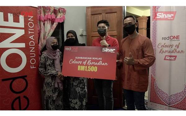 Sabariah bersama anaknya menerima sumbangan wang berjumlah RM1,500 daripada redONE.