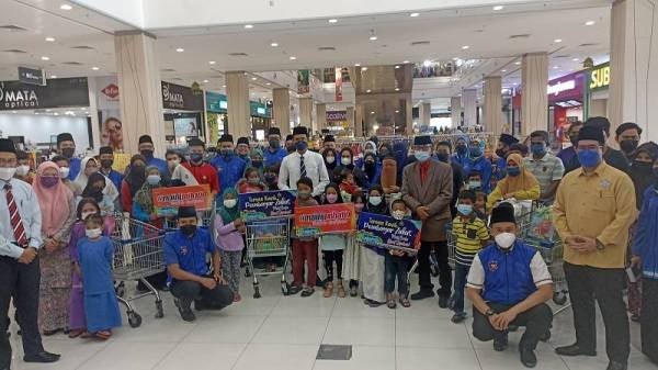 Mohd Fared (tengah) bergambar bersama penerima program Belanja Bersama Raya Asnaf 2022 di Mydin Mall Mutiara Rini pada Selasa.