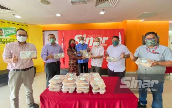 Suriati (tiga dari kiri) menyerahkan sumbangan kepada Muhammad Nasir di Ibu Pejabat Sinar Harian di Shah Alam pada Selasa.