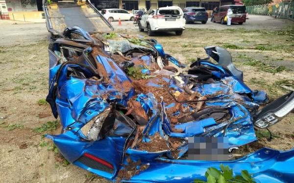 Keadaan salah sebuah kereta yang ranap sepenuhnya setelah dihempap pokok tumbang di tempat letak kereta Hospital Lama Sungai Petani pada Selasa.