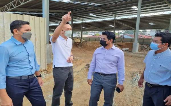 Johary (dua dari kanan) bersama Hian Wah (dua dari kiri) meninjau progres pembinaan pasar transit di SK 3/2, Seri Kembangan pada Selasa.