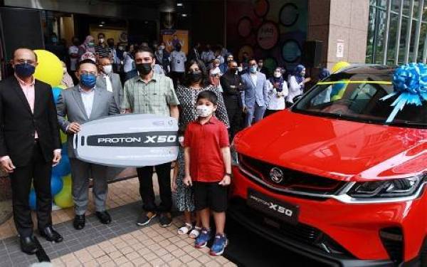 Ahmad Dasuki (kiri) dan Wan Saiful bergambar bersama Hardave Singh Gill dan keluarganya yang memenangi Proton X50 (kategori platinum).