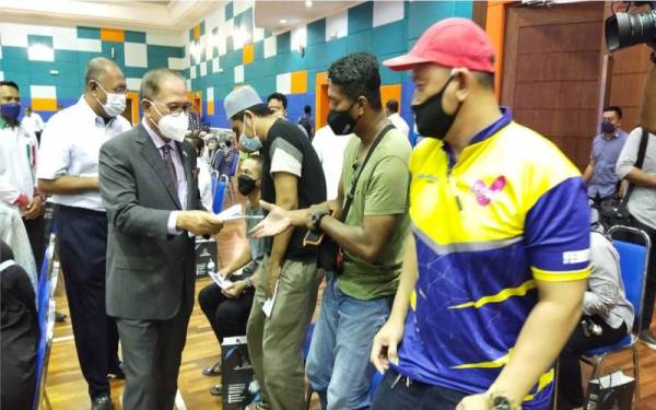 Wan Rosdy menyampaikan sumbangan awal persekolahan murid tahun satu pada Majlis Pelancaran Agihan Bantuan Prihatin Pahang (BPP) 2022 di Dewan Kompleks Majlis Bandaraya Kuantan (MBK), pada Rabu.