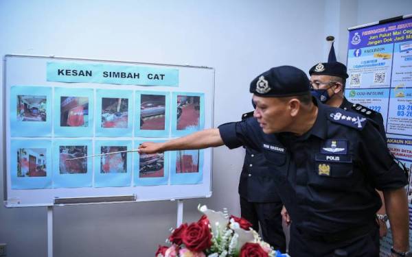Wan Hassan menunjukkan kesan-kesan simbahan cat di rumah mangsa ketika sidang media mengenai penahanan dua lelaki yang dipercayai bersekongkol dengan sindiket pinjaman wang tidak berlesen di Ibu Pejabat Daerah Kota Setar pada Rabu. - Foto Bernama