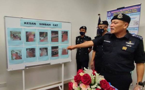 Wan Hassan (kanan) menunjukkan keadaan rumah peminjam yang disimbah cat merah pada sidang media di IPD Kota Setar, di sini, pada Rabu.