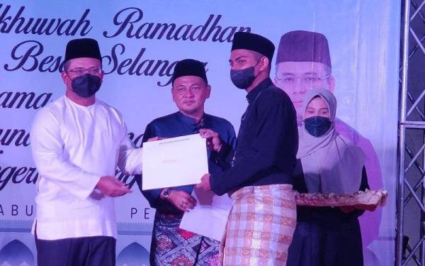 Amirudin (kiri) menyampaikan sumbangan kepada pelajar pada Majlis Jalinan Ukhwah Ramadan di STDC di sini pada Rabu.